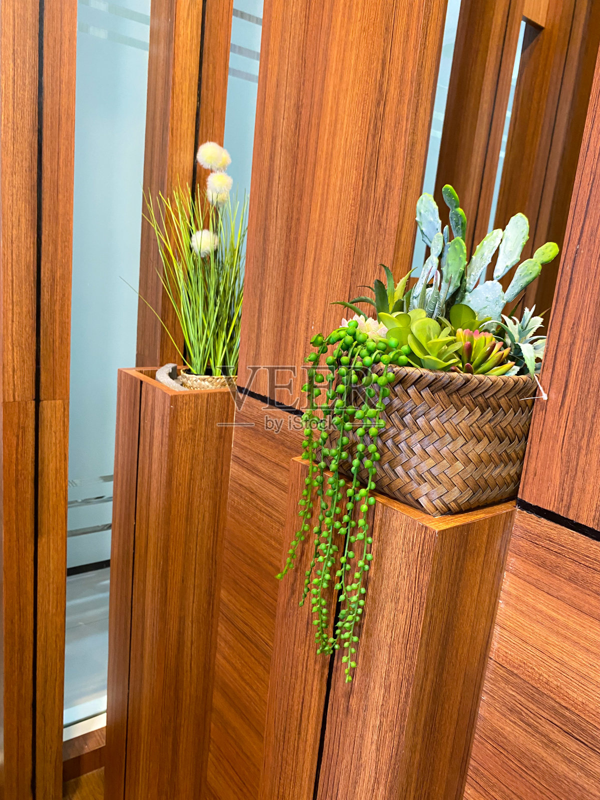 人造植物装饰在房间角落的木柱之间照片摄影图片