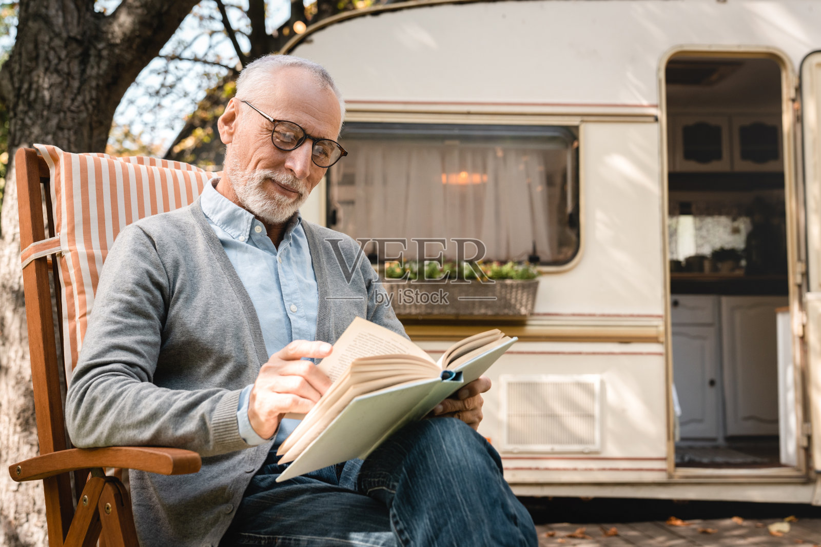 年长的老人在旅行时读书学习照片摄影图片