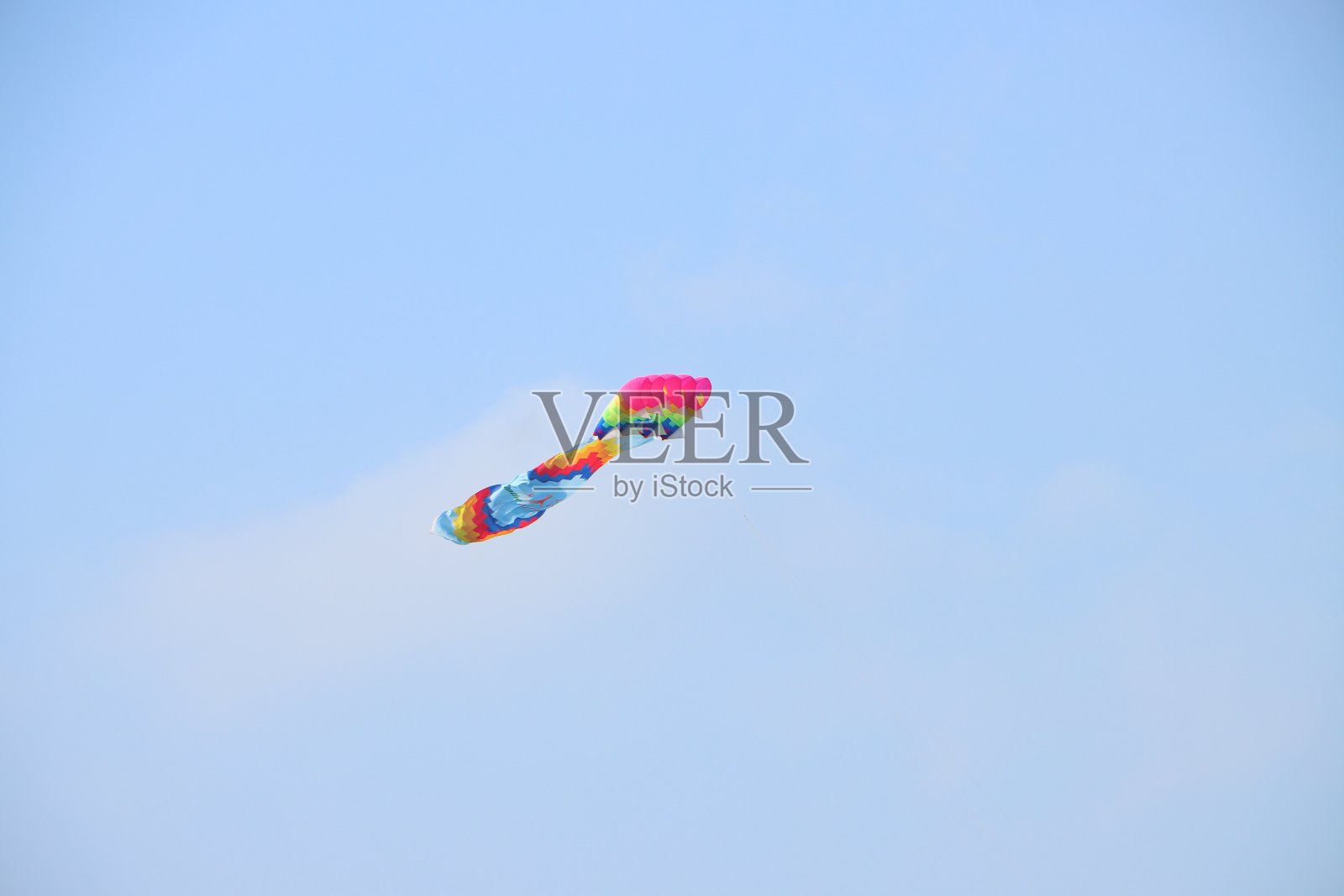 在越南湄公河三角洲,五彩缤纷的风筝在夏日蔚蓝的天空中飞翔。快乐的童年时光。照片摄影图片