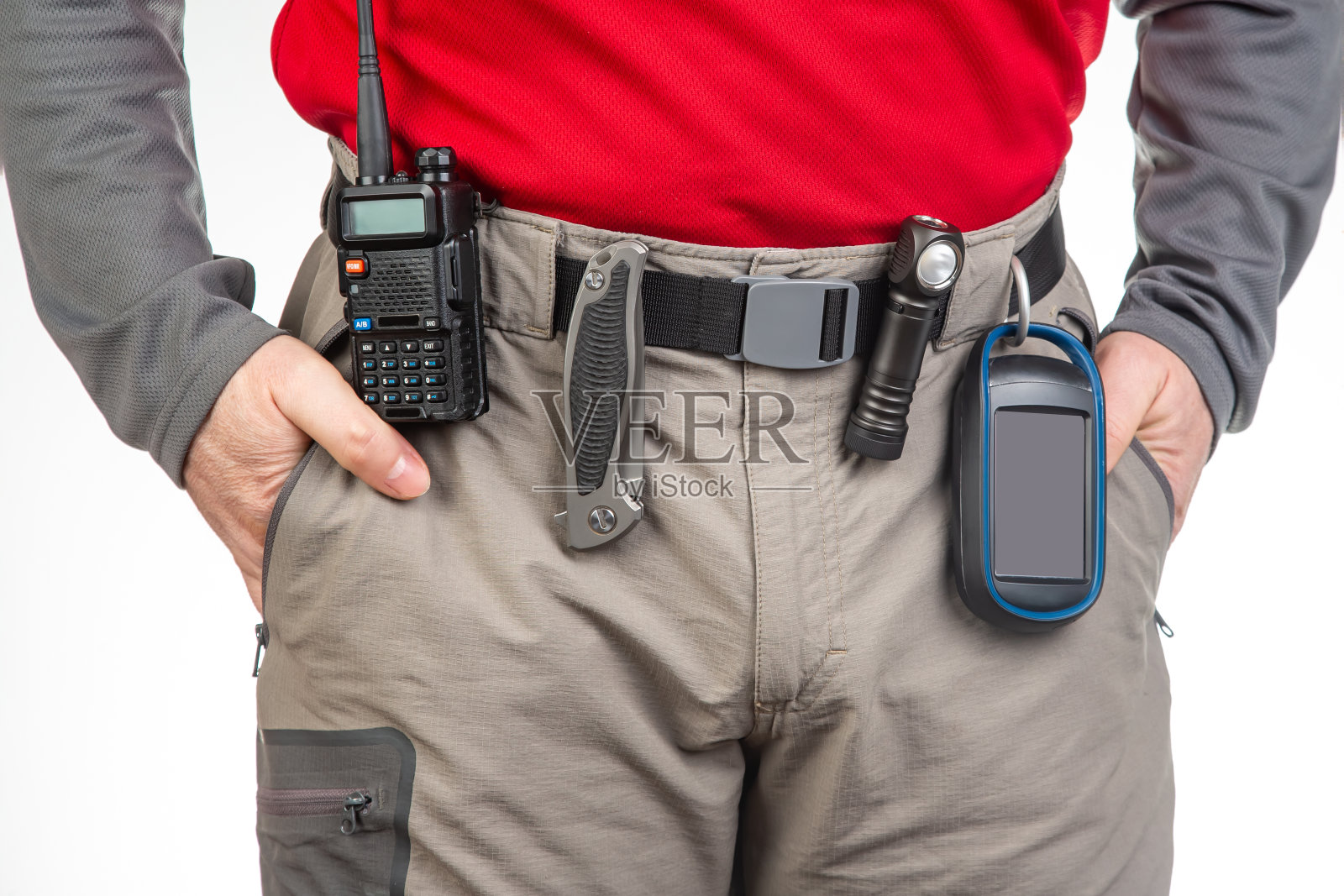 对讲机、手电筒、小刀、旅行者徒步裤腰带上的GPS导航仪。旅游旅游设备。EDC的物品照片摄影图片