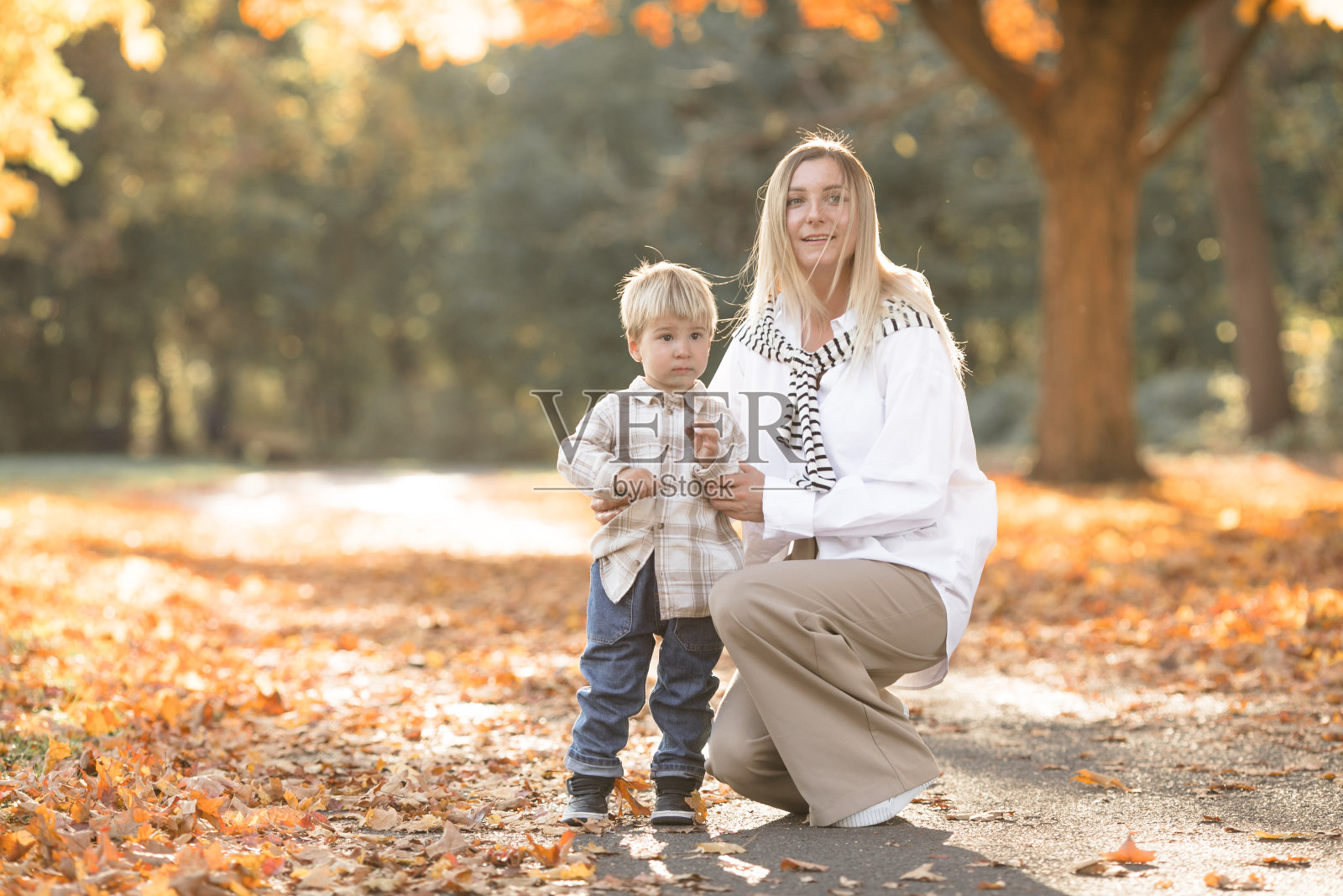 母亲节,爱家人。秋天一家人在大自然中散步。母亲和孩子拥抱温柔照片摄影图片