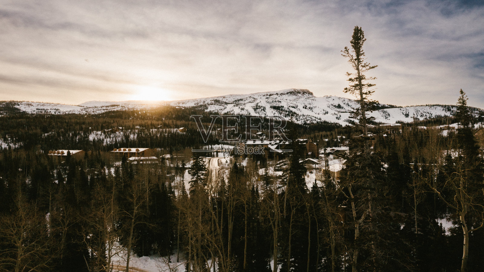 无人机拍摄的雪山高峰在森林与阳光照片摄影图片