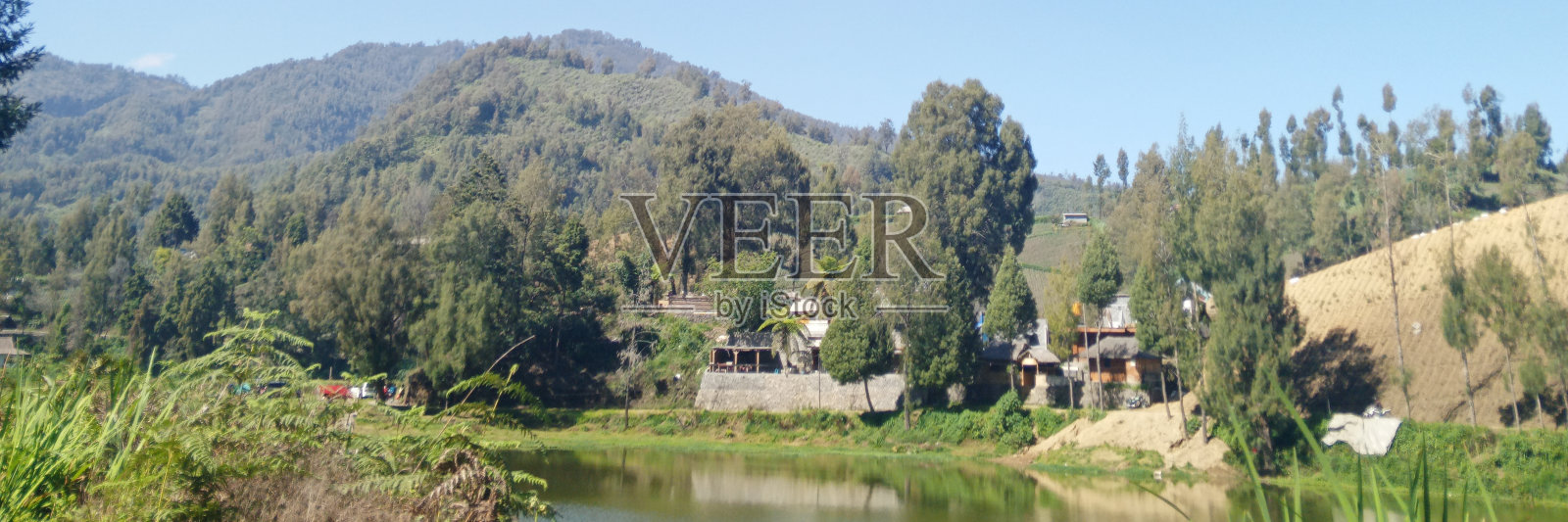 草地中央有一个湖照片摄影图片