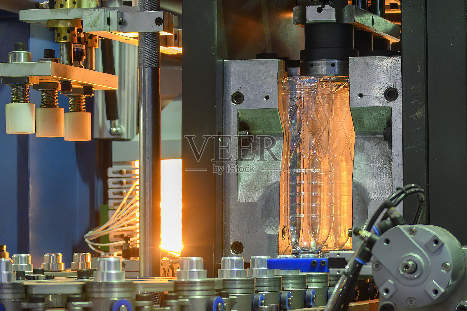 饮水瓶的制造工艺采用吹塑机。照片摄影图片