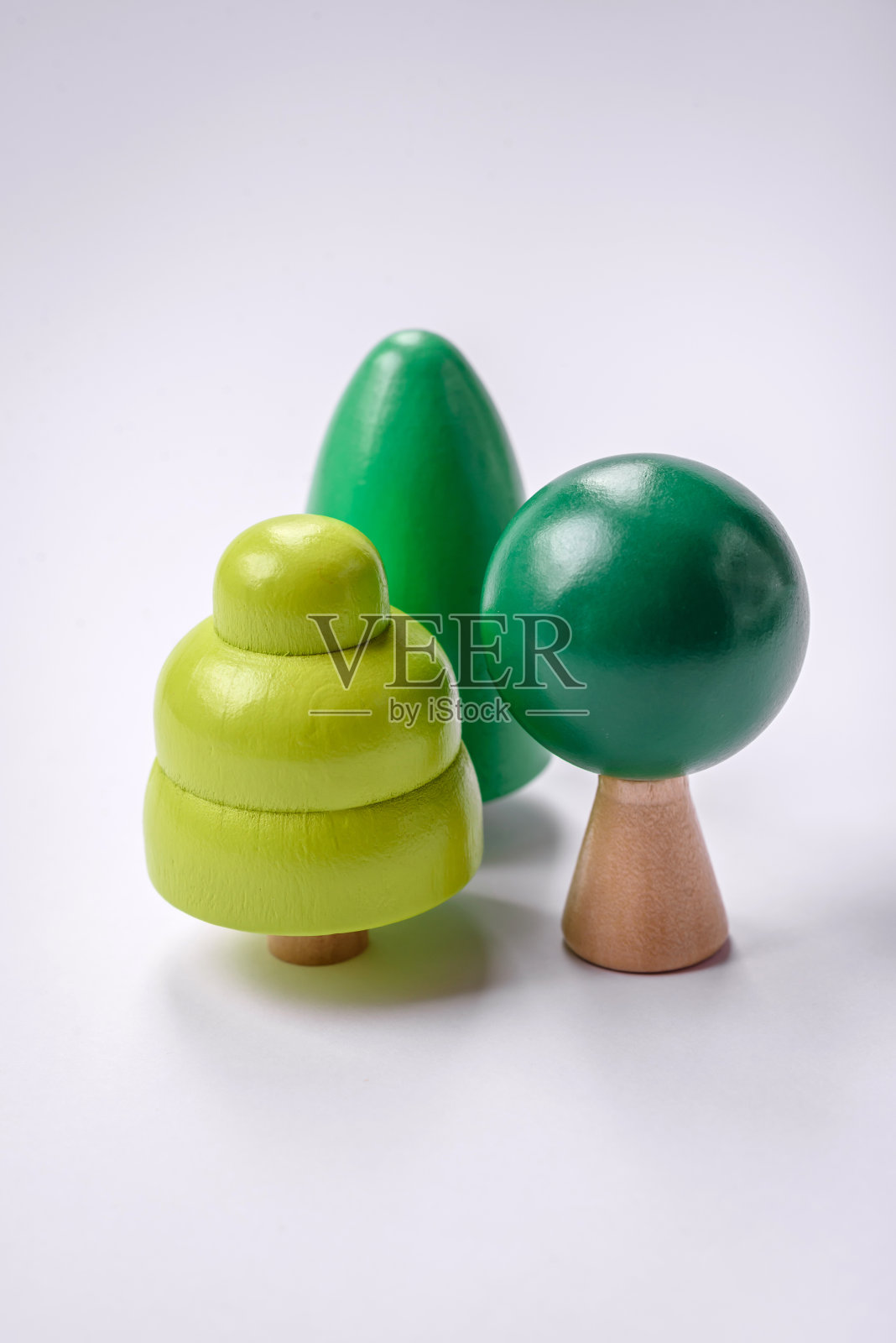 在白色背景上有绿色树冠和树干的木模型照片摄影图片