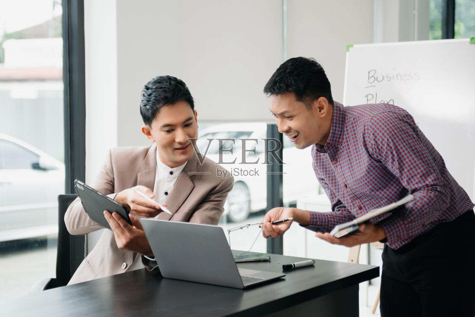 商务人员带领团队开会,在办公室与财务人员一起使用平板电脑和笔记本电脑照片摄影图片