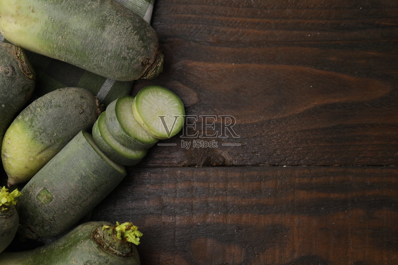 青青的白萝卜放在木桌上,平铺着。文本空间照片摄影图片