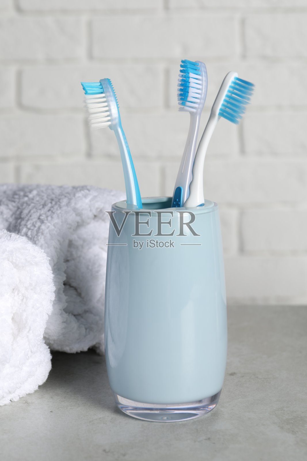 塑料牙刷架和毛巾在浅灰色的桌子上照片摄影图片