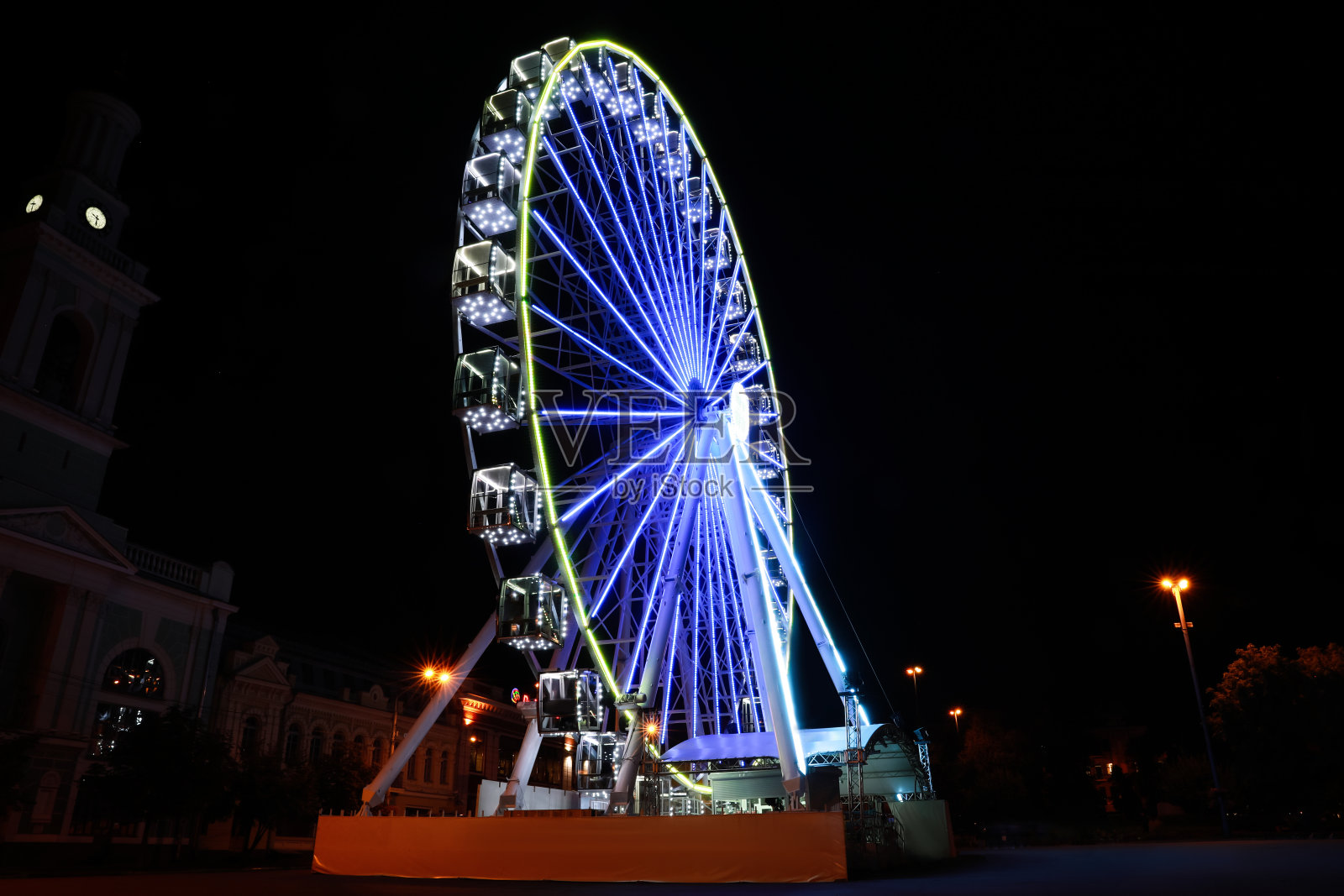 夜晚城市街道上美丽的发光摩天轮照片摄影图片