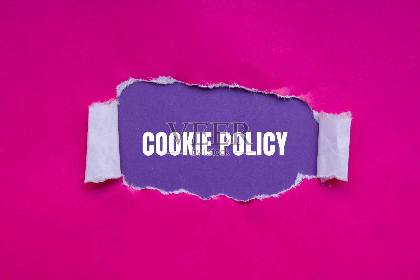 饼干政策的文字写在粉红色的破纸上,紫色的背景照片摄影图片