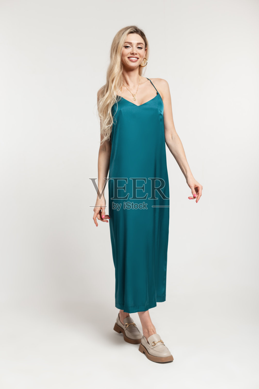 幸福的金发美女,穿着时尚复古优雅的绑带裙和鞋子,站在白色背景的工作室里摆姿势照片摄影图片