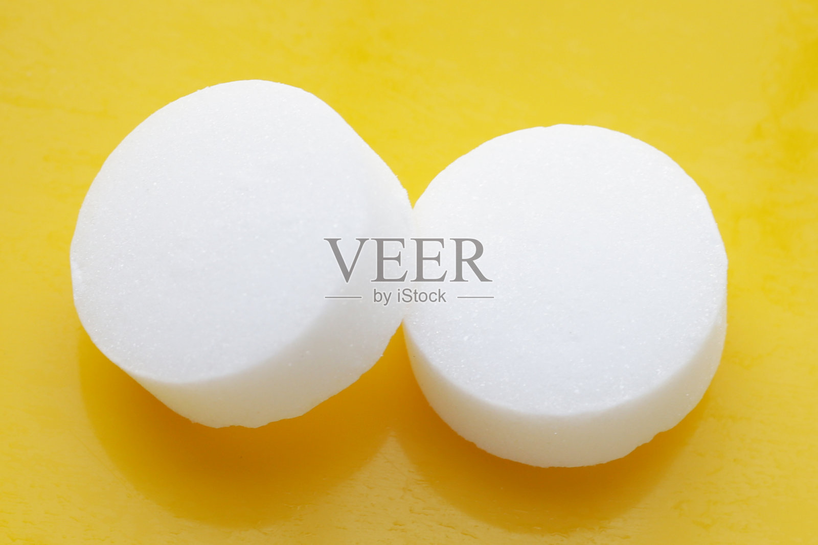 黄色背景上的白色樟脑丸。照片摄影图片