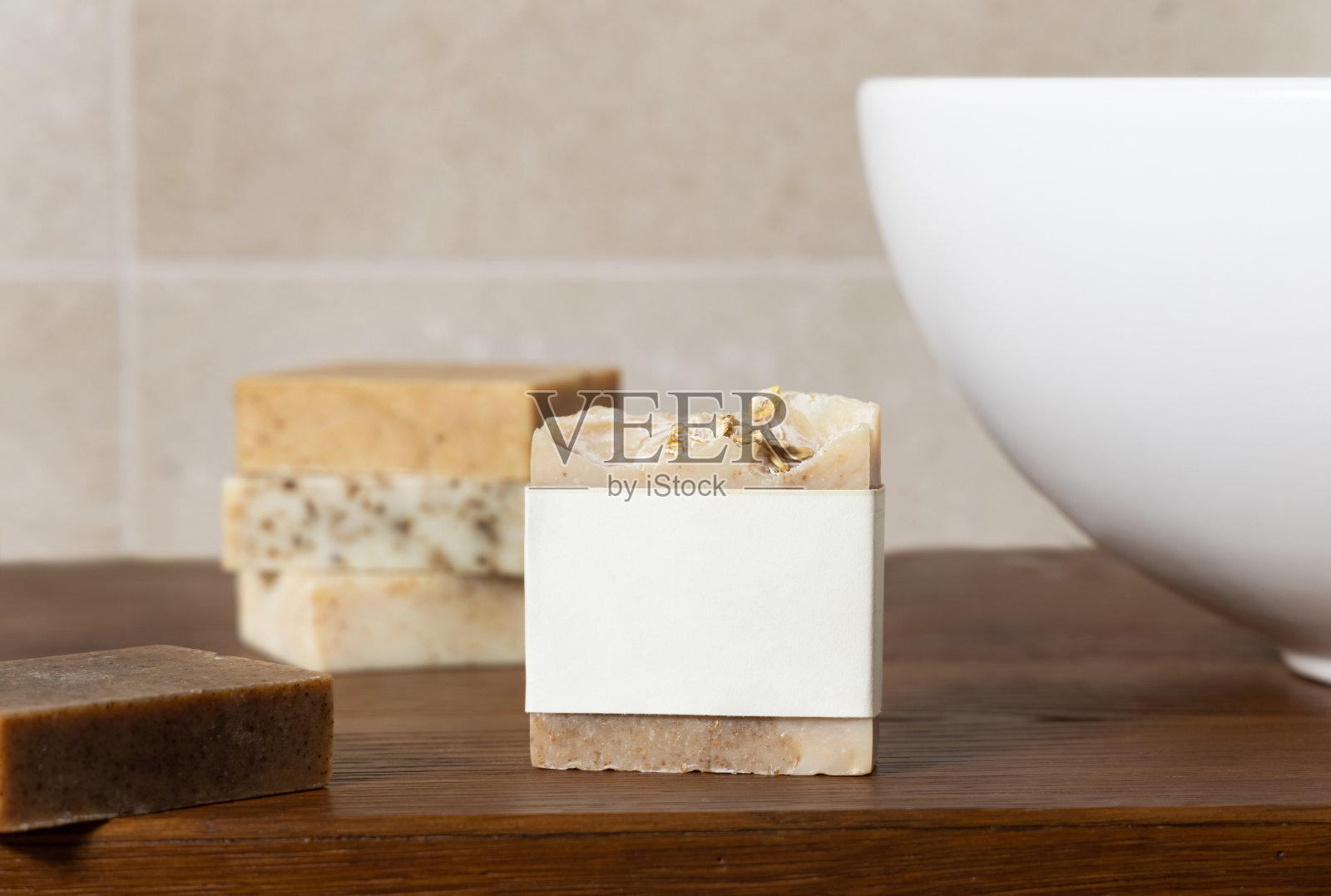 洗澡间木质台面上有空白标签的肥皂吧,紧贴米色墙壁照片摄影图片