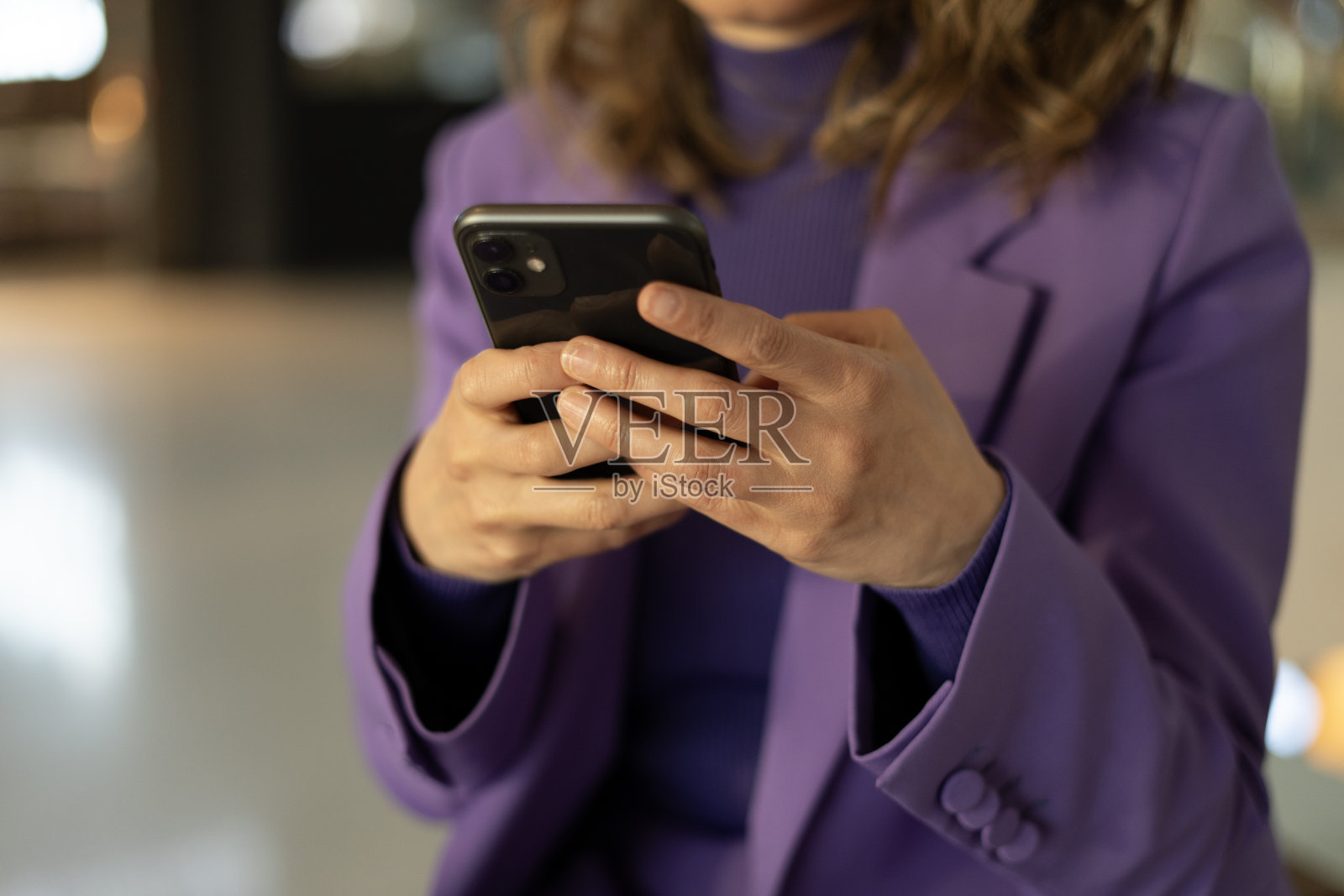 特写:一位女士在购物中心使用智能手机照片摄影图片