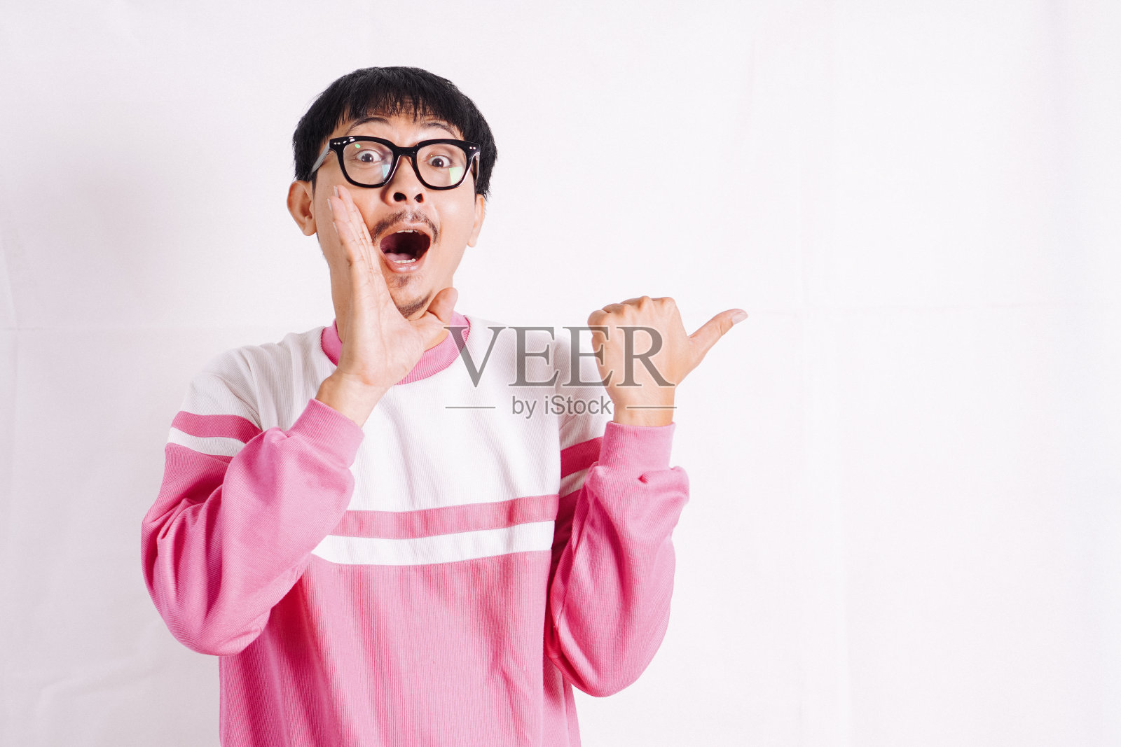 大声喊出来。兴奋的年轻亚洲男子用手靠近嘴宣布。照片摄影图片