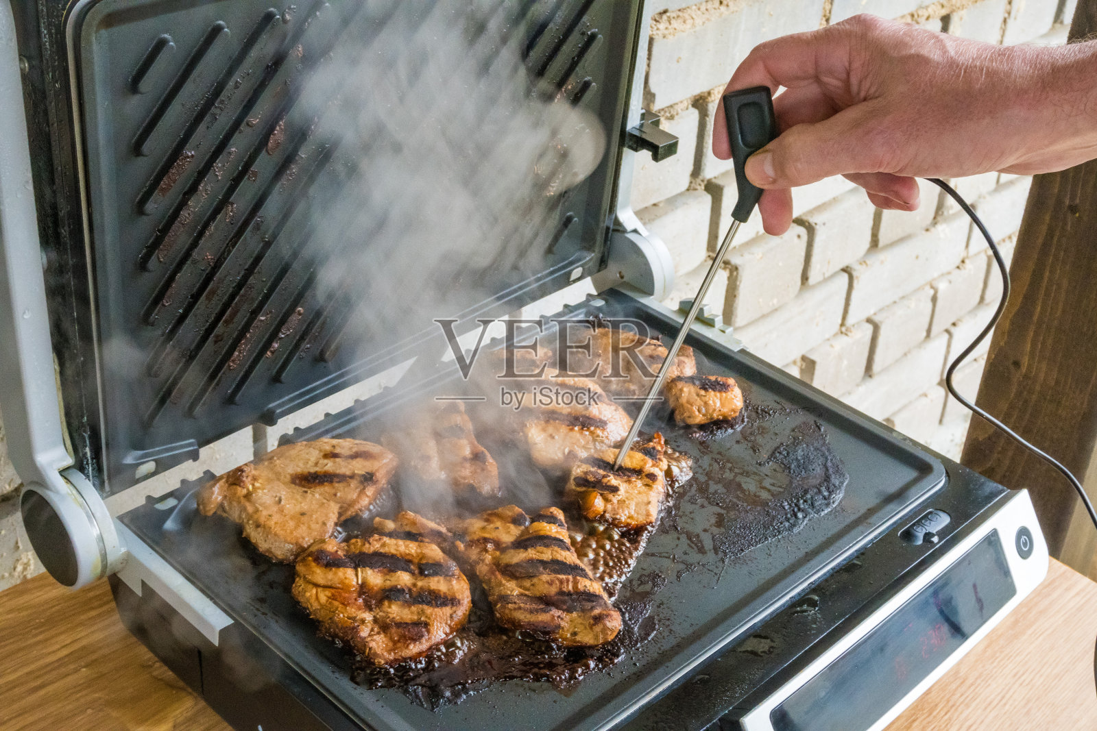 通过测量温度来检查牛排的熟度。烤牛排照片摄影图片