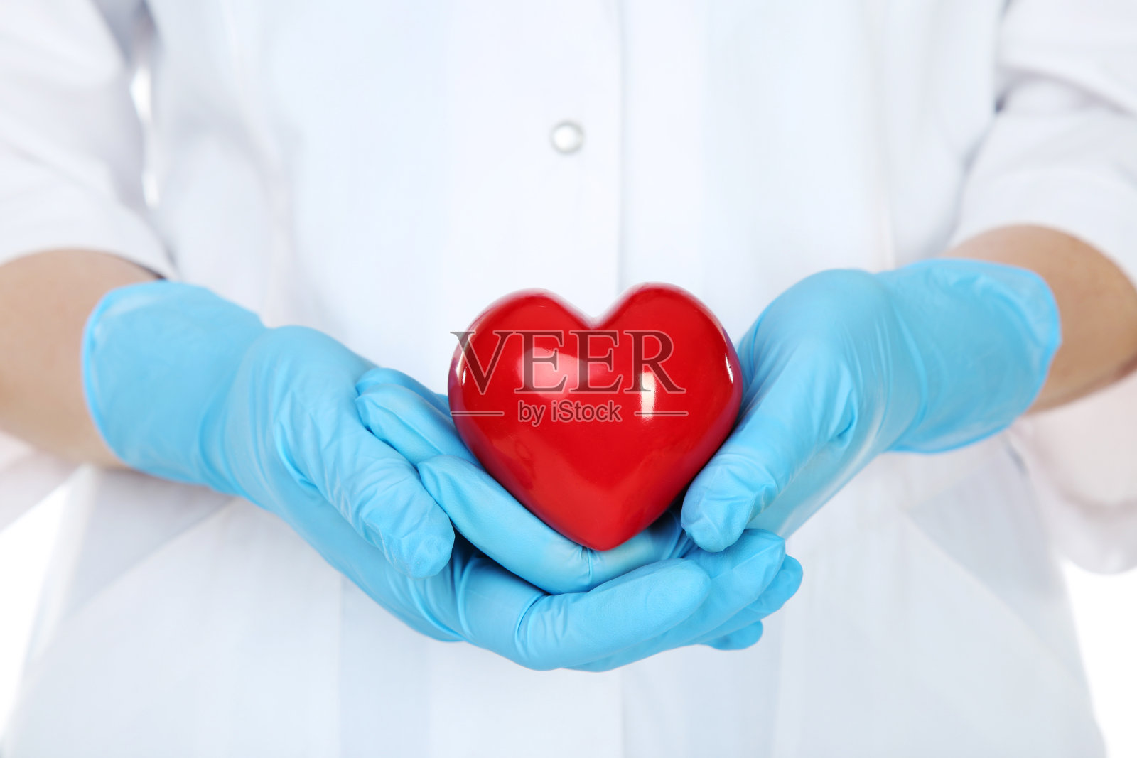 医生双手戴着手套捧着红心照片摄影图片