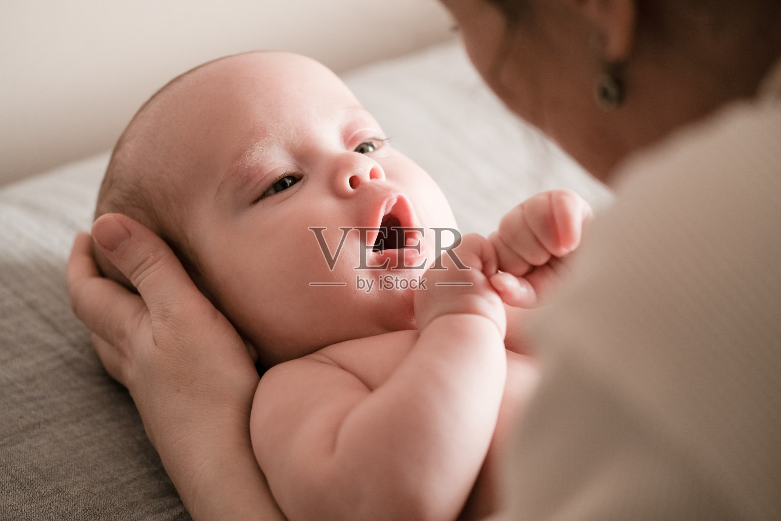可爱的小婴儿躺在床上的特写肖像。母亲和她刚出生的婴儿。照片摄影图片
