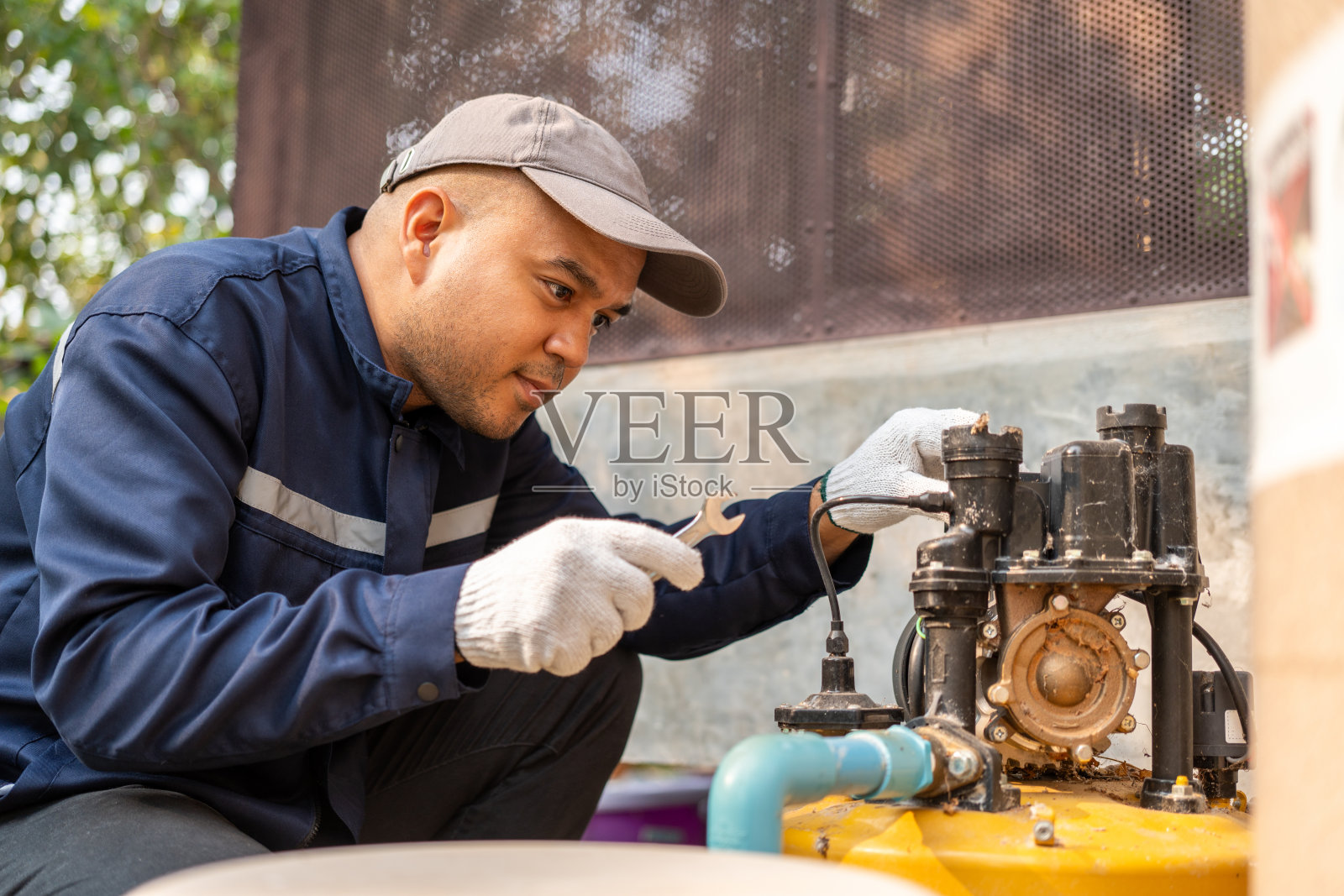 男水管工正在安装管道系统,手握水龙头。管道检查服务和维修。照片摄影图片