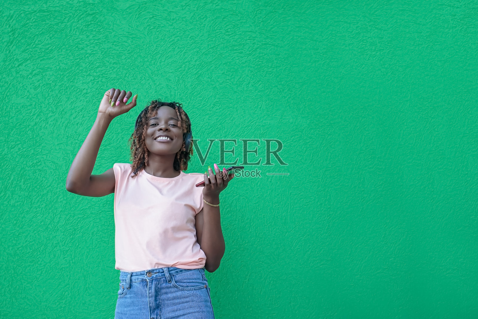 一位戴着耳机微笑的女士正在听音乐。无线技术。本空间照片摄影图片