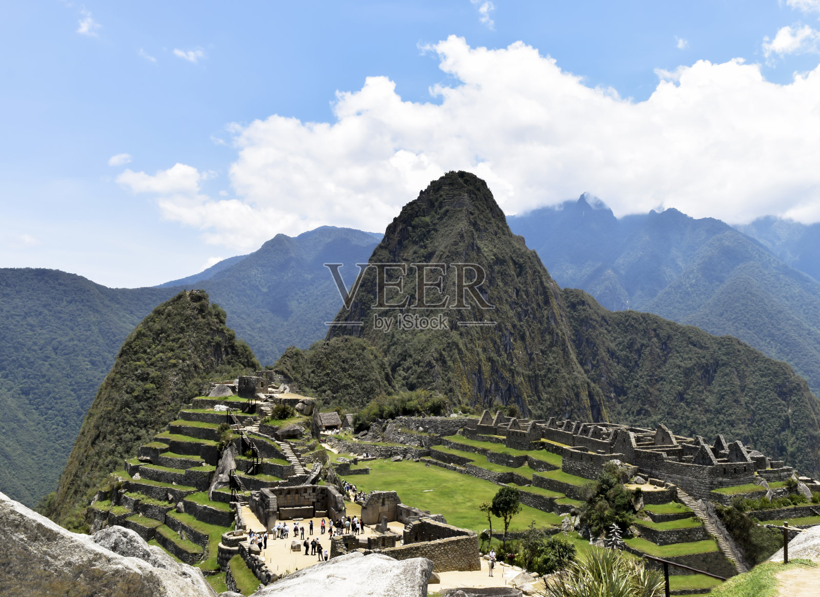 马丘比丘废墟与游客戏剧性的云,。秘鲁库斯科,历史悠久的圣所,农业梯田的全景图,韦纳比丘和周围山脉照片摄影图片