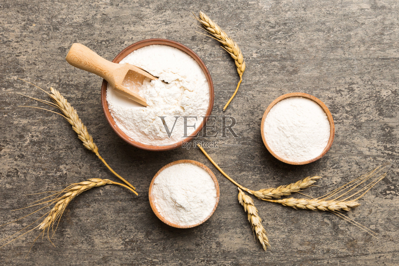 在木碗中平铺小麦粉,背景上有小麦小穗。世界小麦危机照片摄影图片