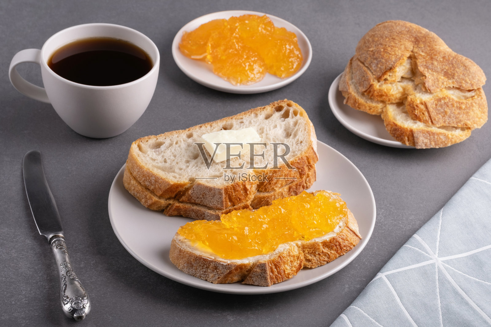 灰色背景上的杏果酱三明治和一杯咖啡。早餐的概念照片摄影图片