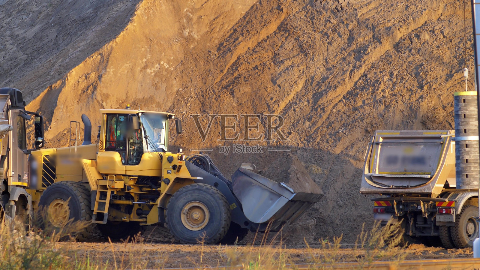 前装载机在工地上用自卸车装载沙子照片摄影图片