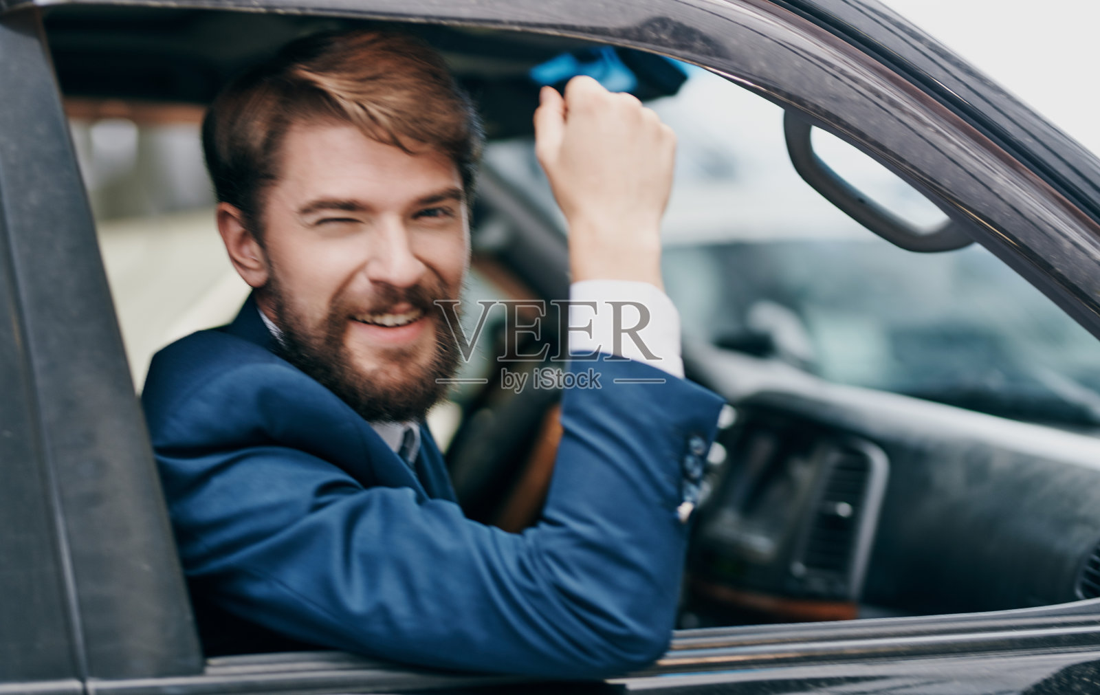 一个西装革履的男人看着窗外的汽车骑着乐趣的生活方式照片摄影图片