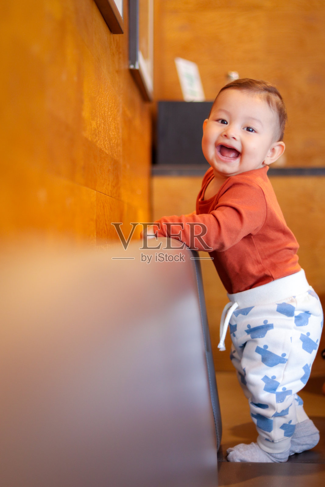 快乐微笑的小男孩站在沙发上照片摄影图片