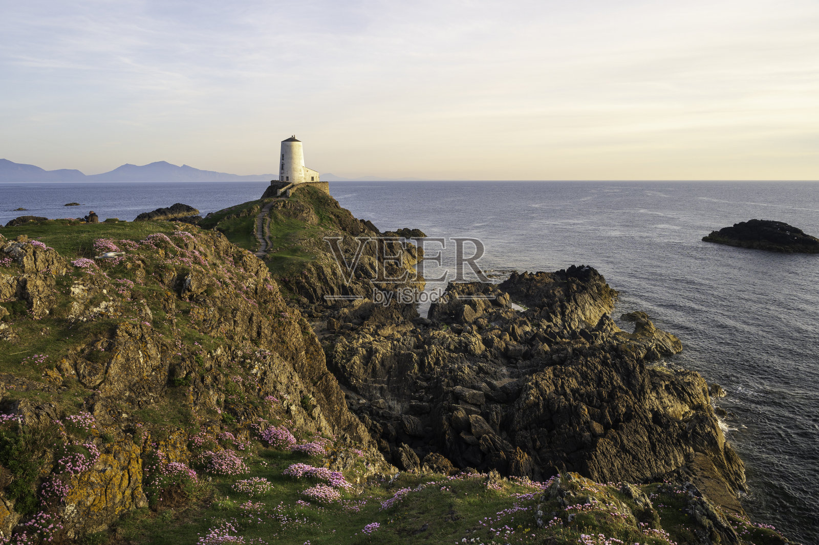 北威尔士安格尔西岛Ynys Llanddwyn岛上日落时雄伟的Twr Mawr灯塔。照片摄影图片