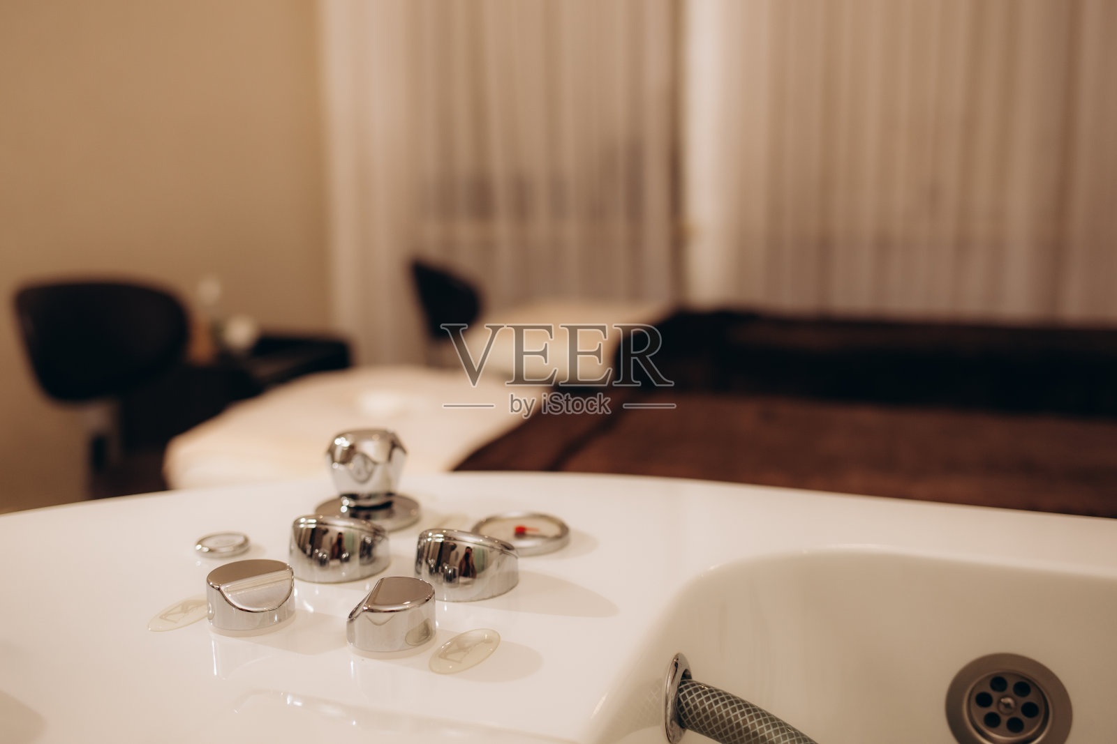 带旋涡水的按摩浴缸和浴室里的棕色马赛克照片摄影图片