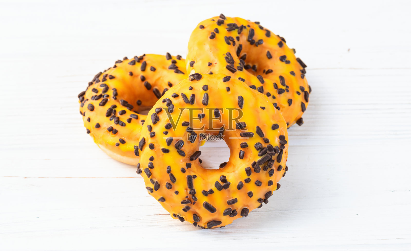 木制背景上的彩色甜甜圈照片摄影图片