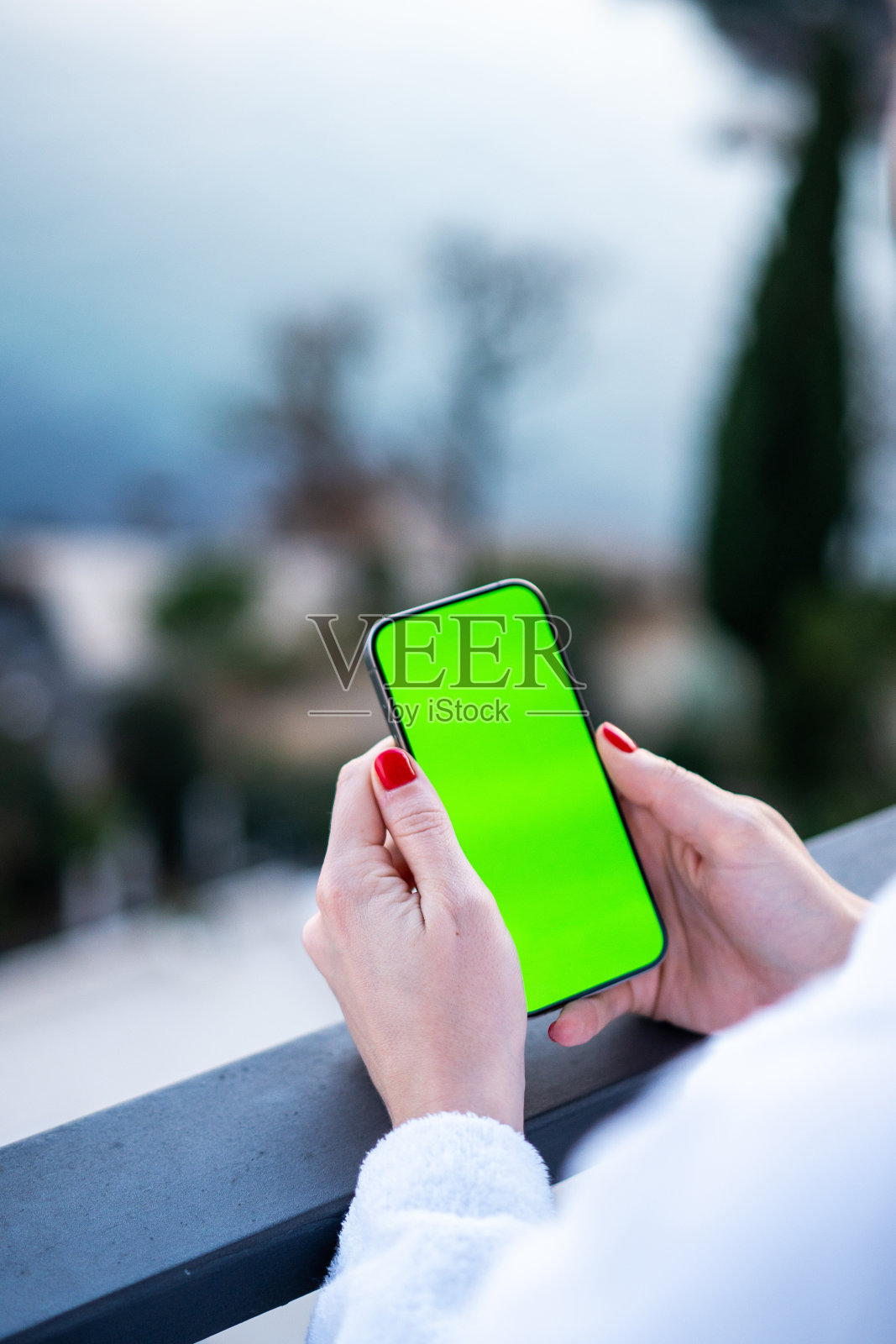 小女孩在海边阳台上用绿屏手机拍照照片摄影图片