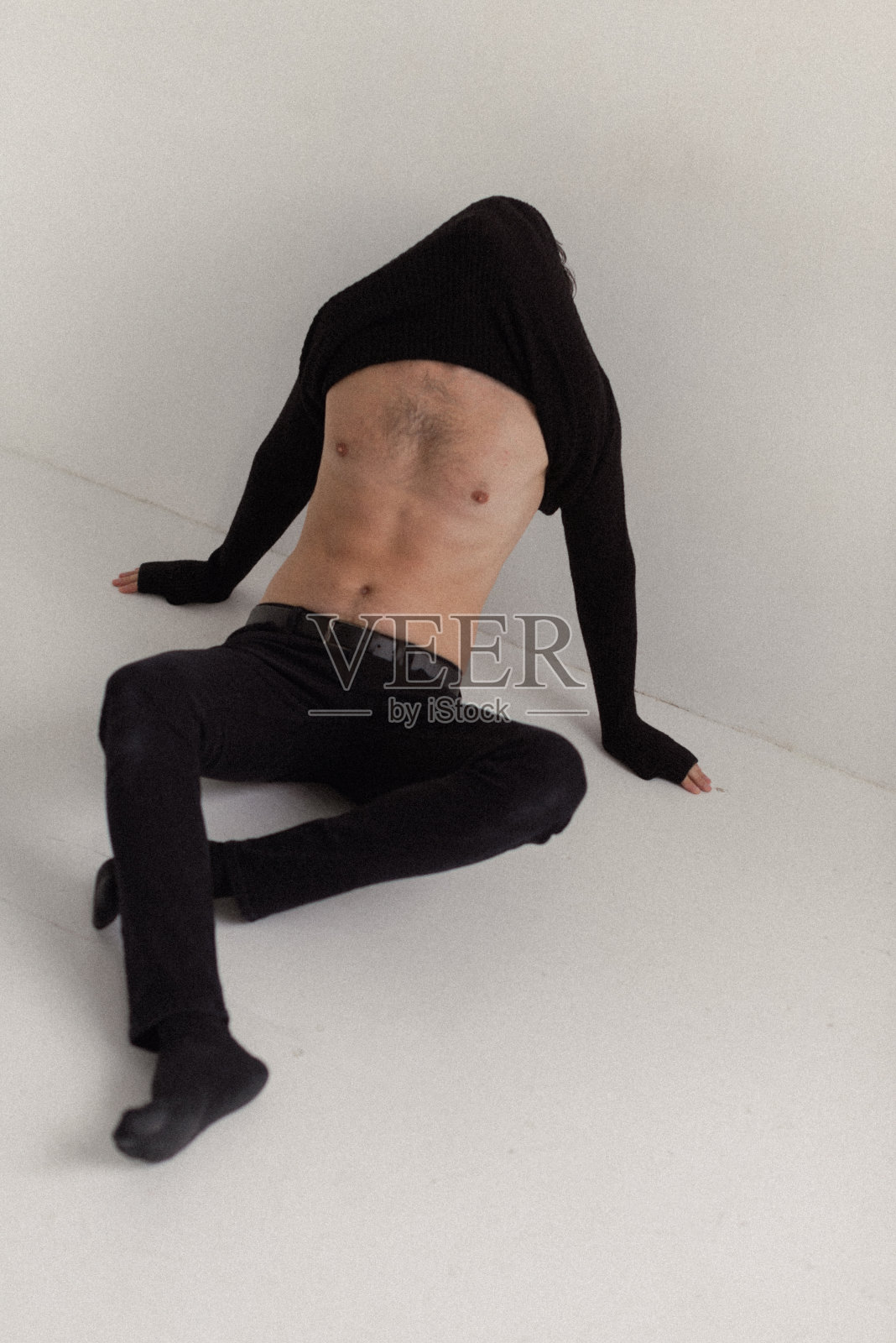 那人脱下衣服,脱掉他的黑毛衣照片摄影图片