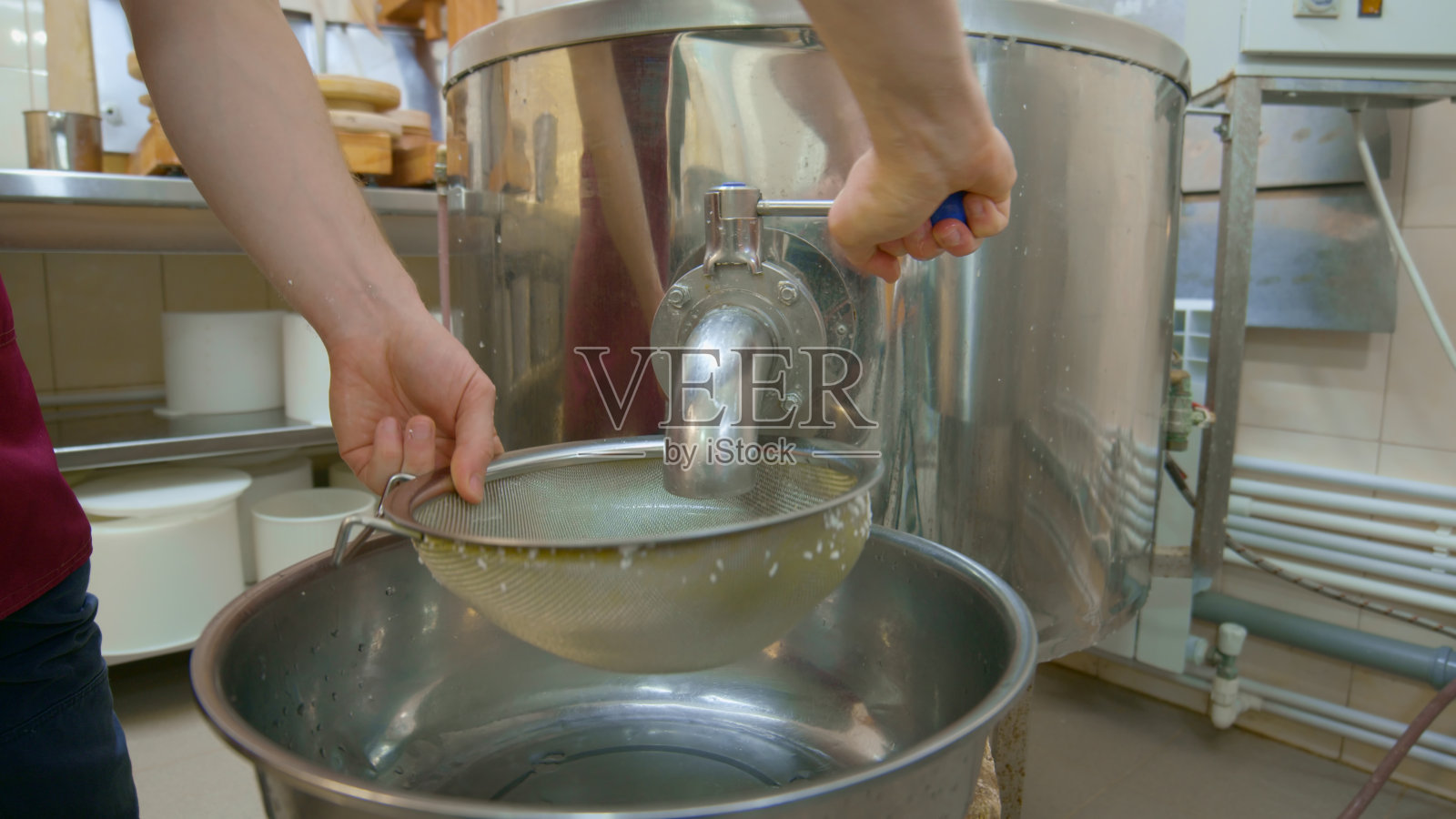 奶酪厂的工人正准备从大桶中排出液体照片摄影图片