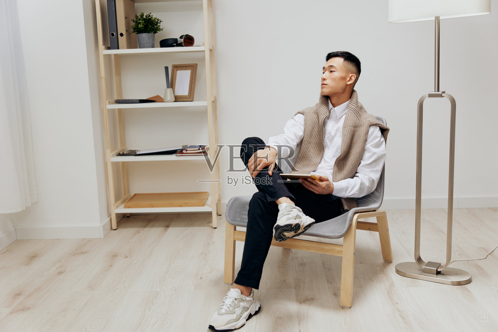 亚洲人在房间里用平板电脑在椅子上休息科技照片摄影图片