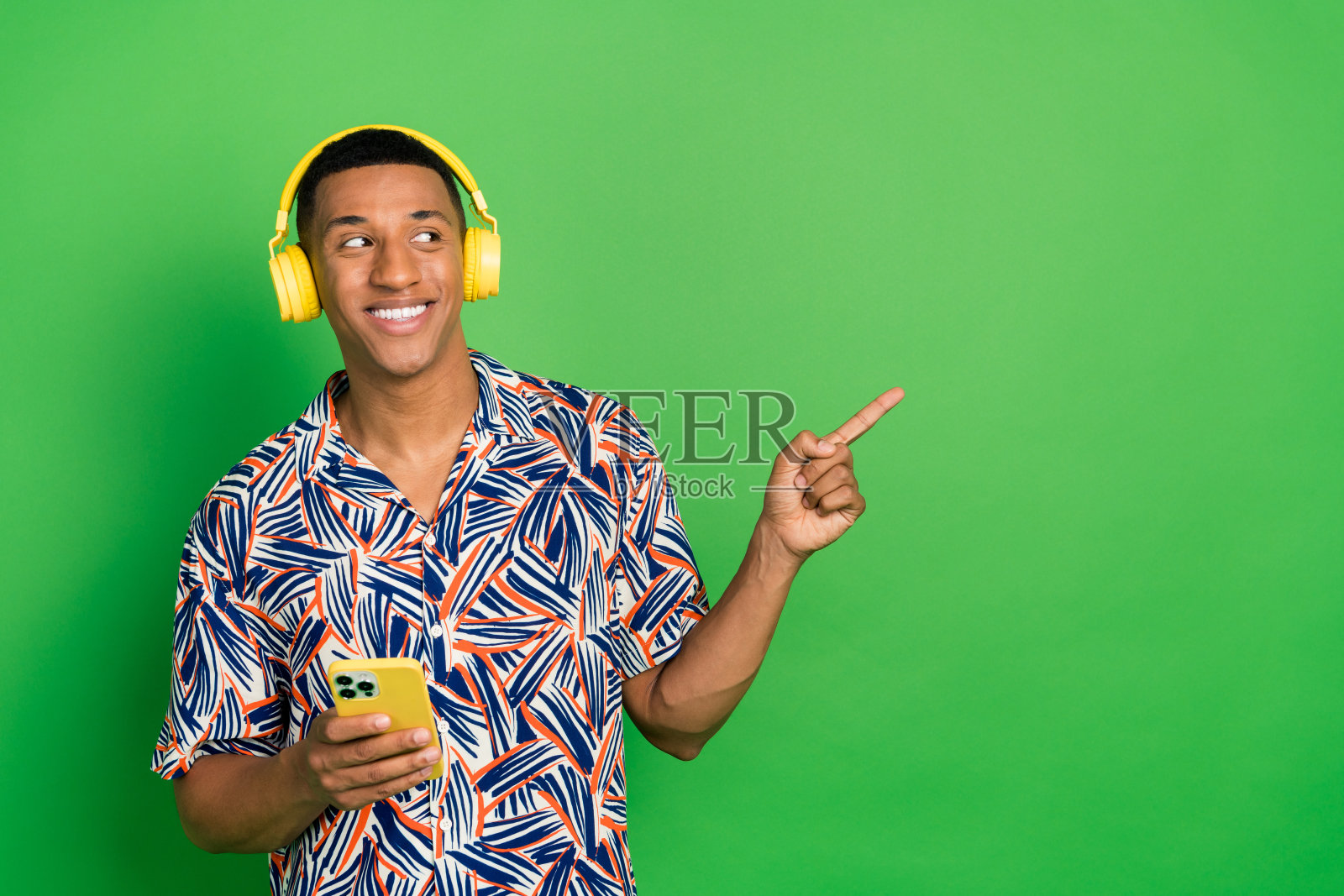 照片积极的家伙模型听蓝牙无线设备空空间销售折扣现代商店孤立的绿色背景照片摄影图片
