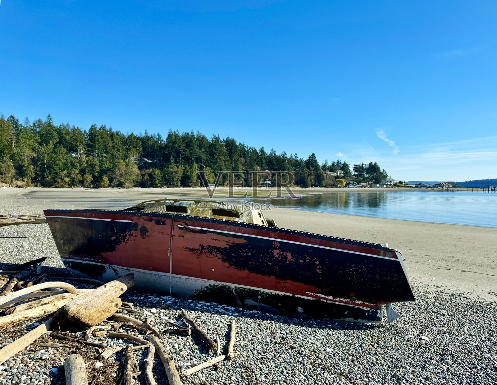 退潮时搁浅的帆船,背景是沿海社区照片摄影图片