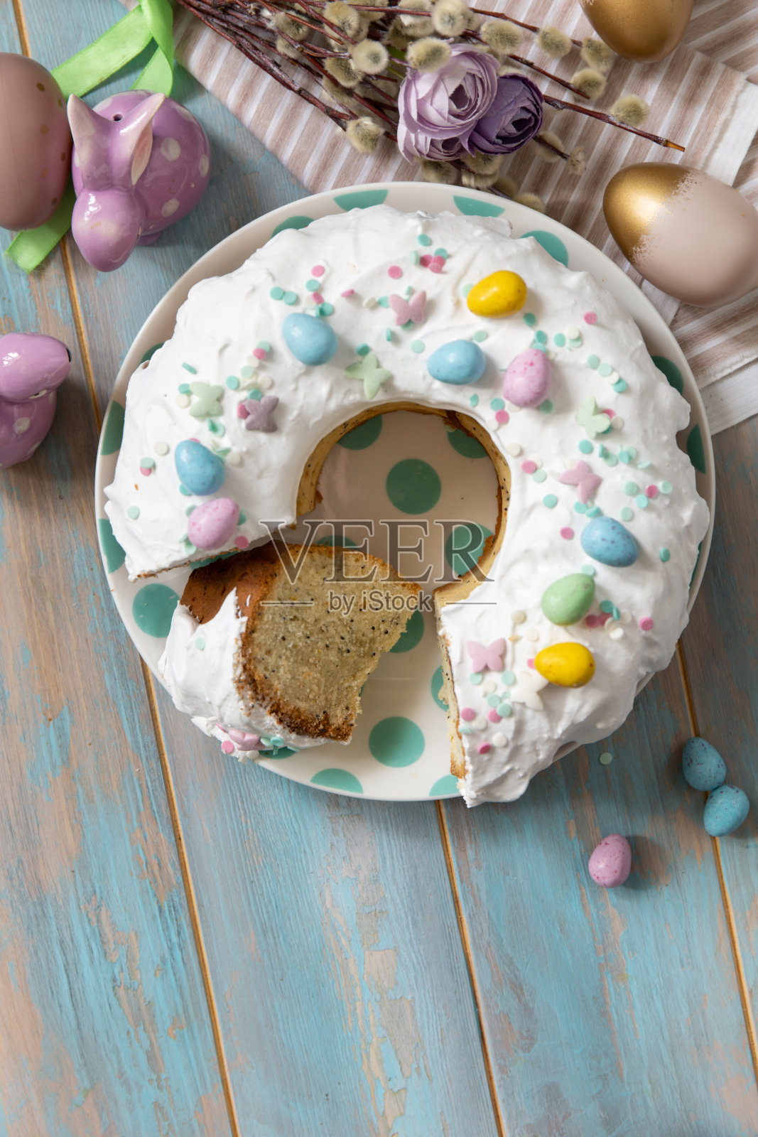 木质桌子上装饰着糖果和迷你巧克力蛋糖的复活节柠檬蛋糕。照片摄影图片