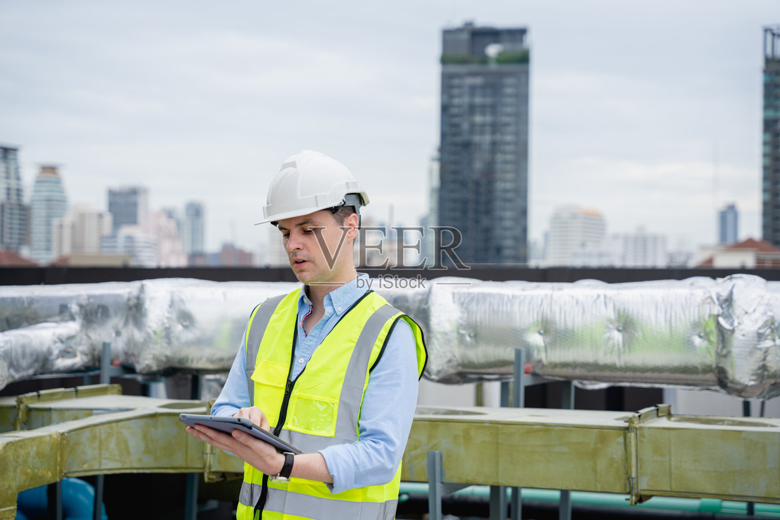 工程师正在检查大型建筑物或工业设施的空调冷却系统。照片摄影图片
