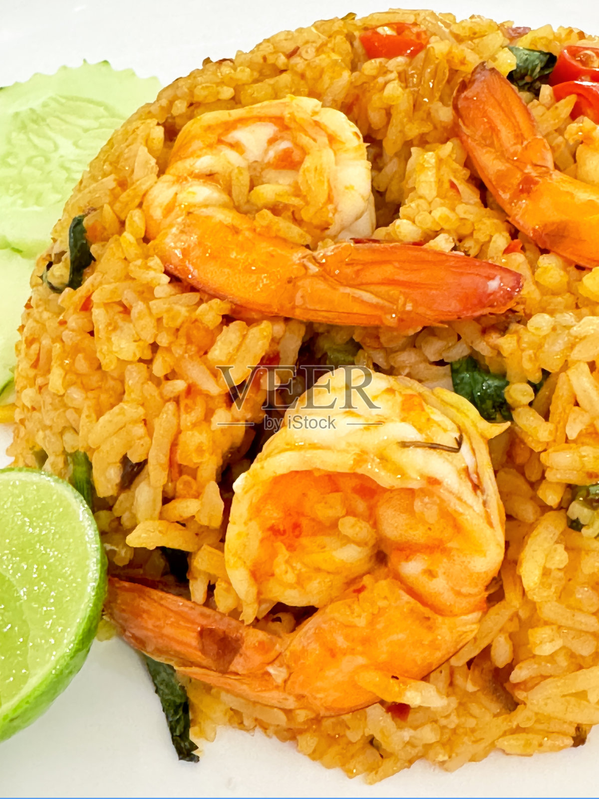 白色盘子的全画幅图像,里面有泰国虾炒饭(Khao Pad Goong)、茉莉花饭、带尾巴的虾、洋葱、中国西兰花叶、切碎的鱼酱红辣椒(prik nam pla)和酸橙角照片摄影图片