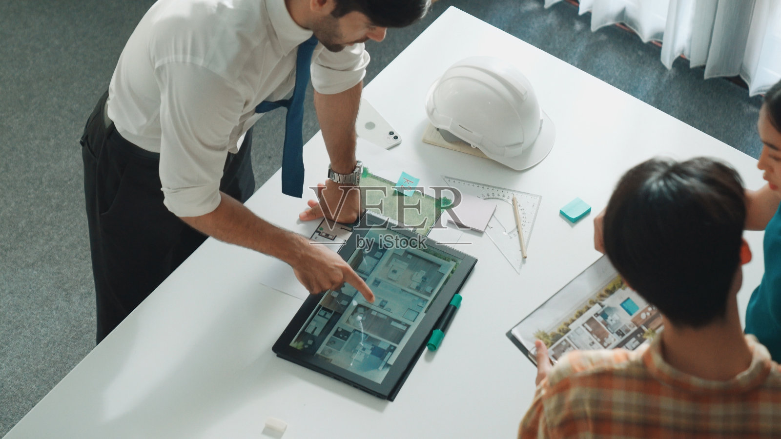 智能经理的俯视图指向房屋模型并解释设计。营养。照片摄影图片