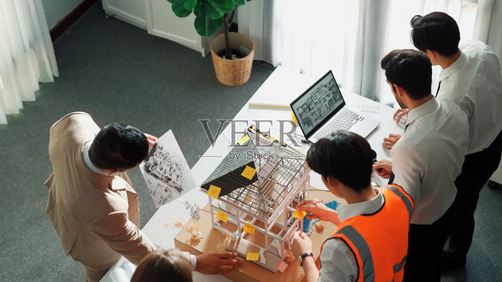 团队俯视图检视房屋模型,经理手持蓝图。营养。照片摄影图片