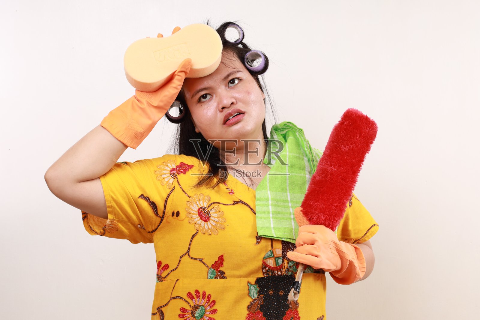 疲惫的亚洲女管家站着拿着清洁工具擦头照片摄影图片