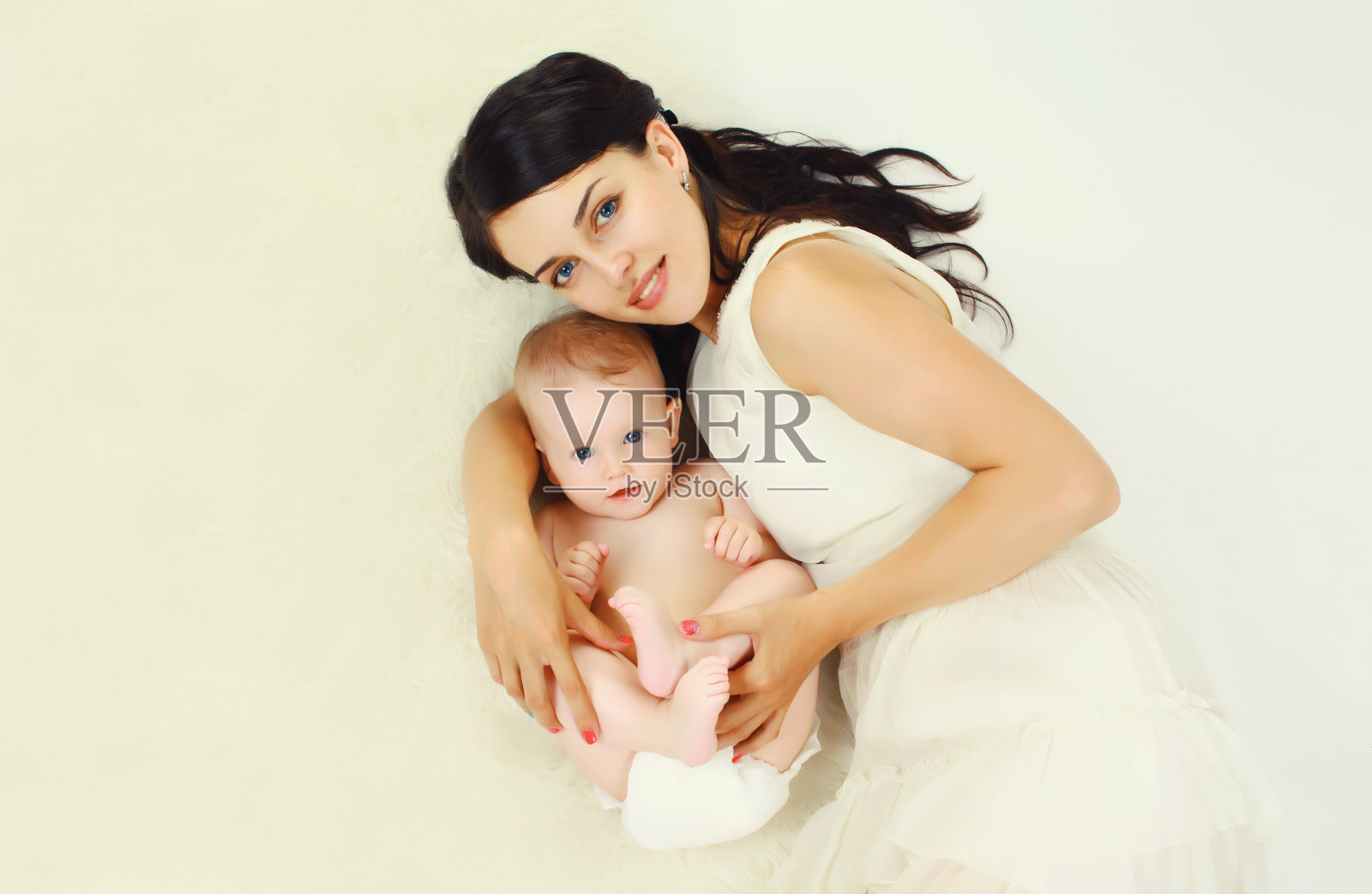 快乐的年轻母亲和孩子一起躺在家里照片摄影图片