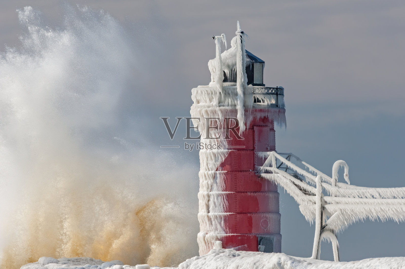 冬天,冰封的南港灯塔溅起浪花照片摄影图片