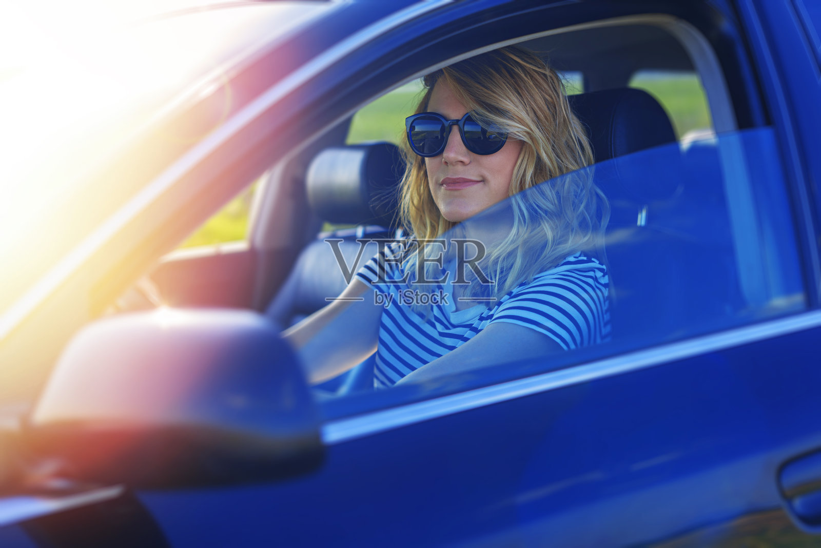 开着车的金发美女。照片摄影图片