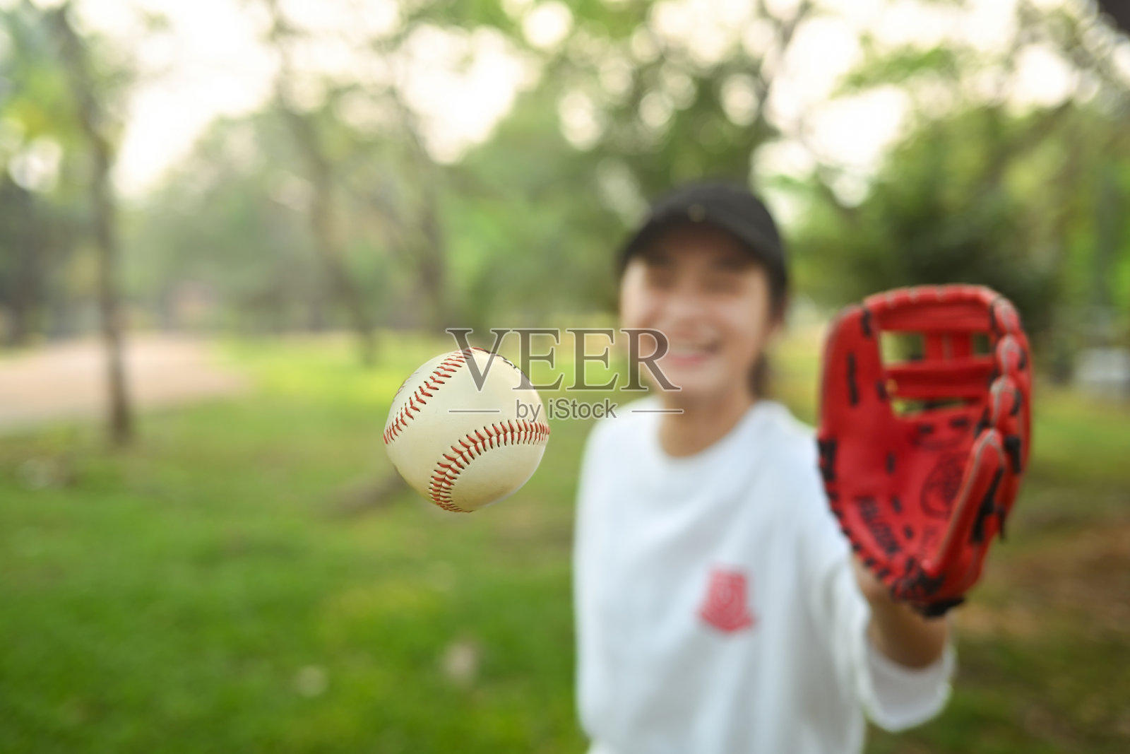 戴着棒球手套的女学生正在接球。运动与青春的生活理念照片摄影图片
