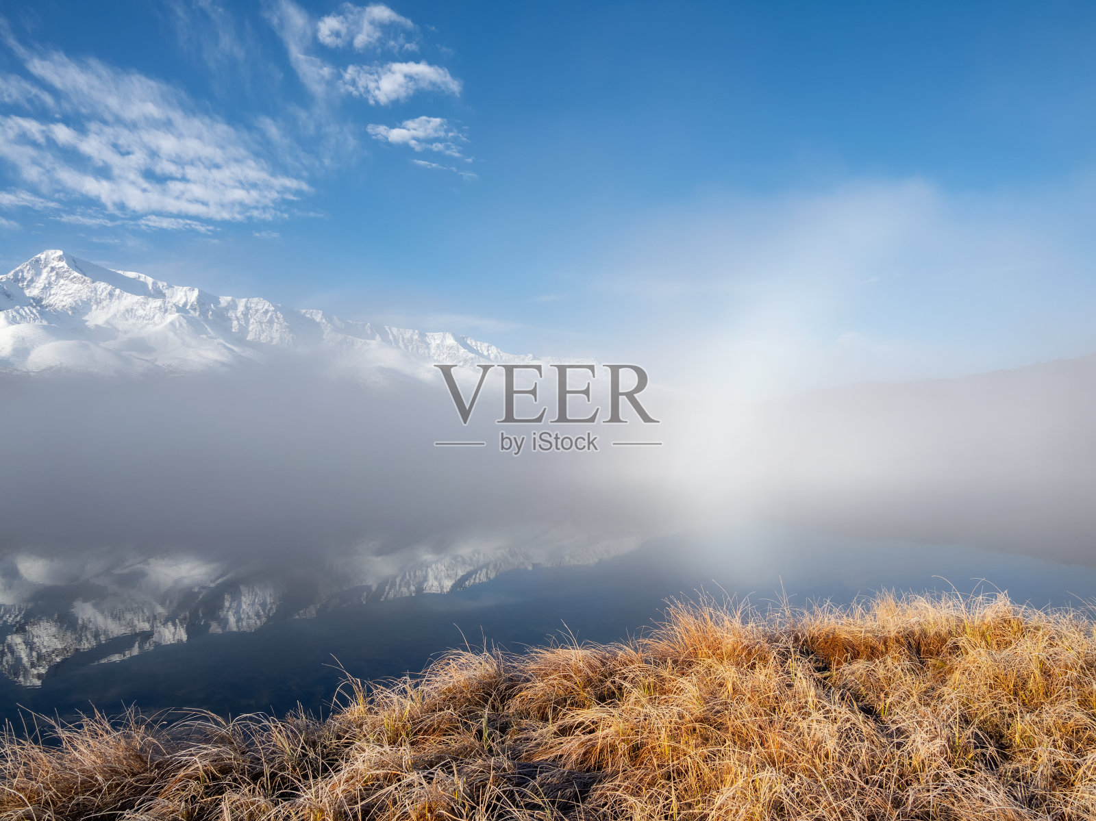 日出在雾气缭绕的山间湖上。照片摄影图片